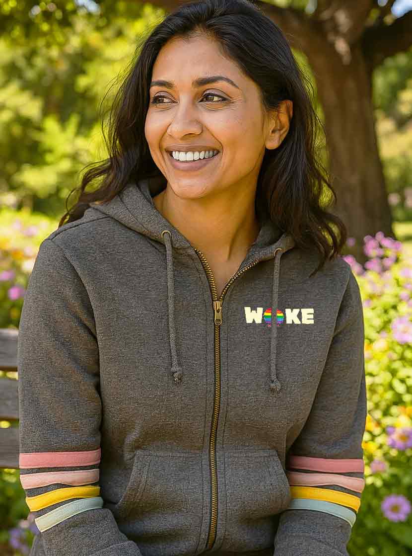 Woman wearing a gray hoodie with 'Woke' logo in a park setting