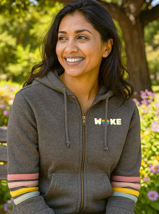 Woman wearing a gray hoodie with 'Woke' logo in a park setting